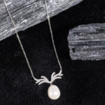 "Graceful antler-shaped pendant necklace accented with a single royal pearl"