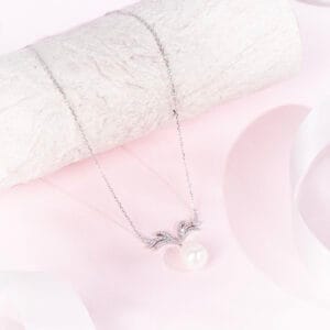 "Graceful antler-shaped pendant necklace accented with a single royal pearl"