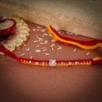 Lion Embossed Silver Rakhi – Red & Yellow Thread with Stone Accents - Image 2