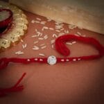 Sacred Red Wool Rakhi – Silver Coin Center with Threaded Accents - Image 2