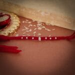 Ganesha Silver Charm Rakhi with Red Thread - Image 2