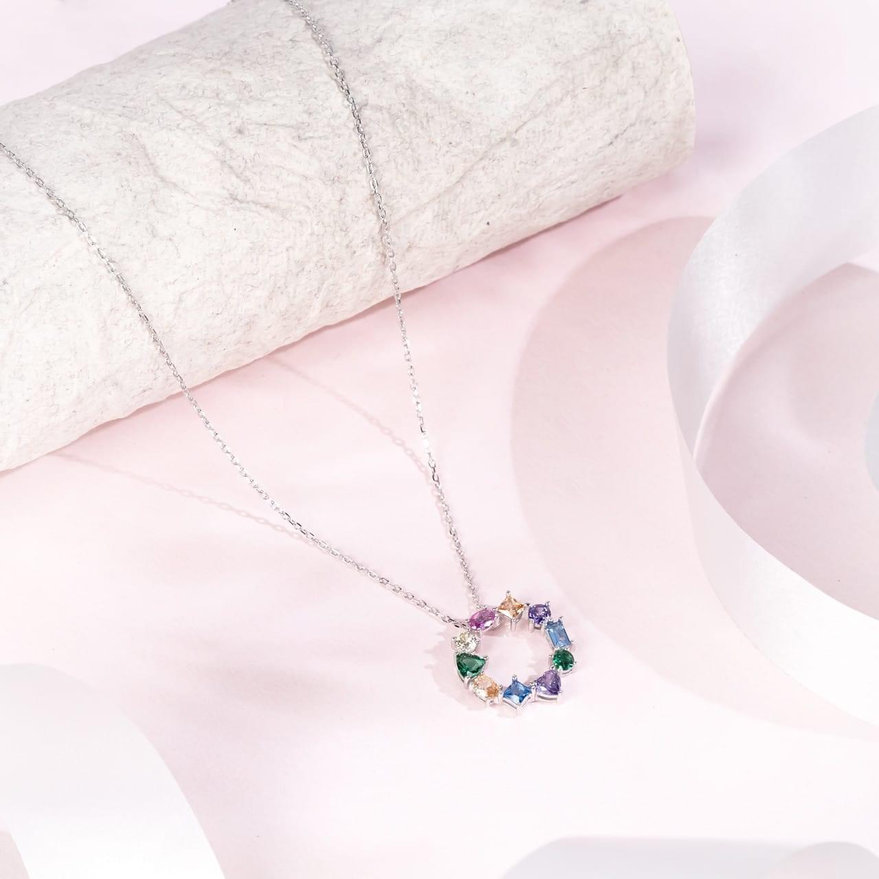 "Multicolor gemstone-studded circle pendant symbolizing unity and vibrance"