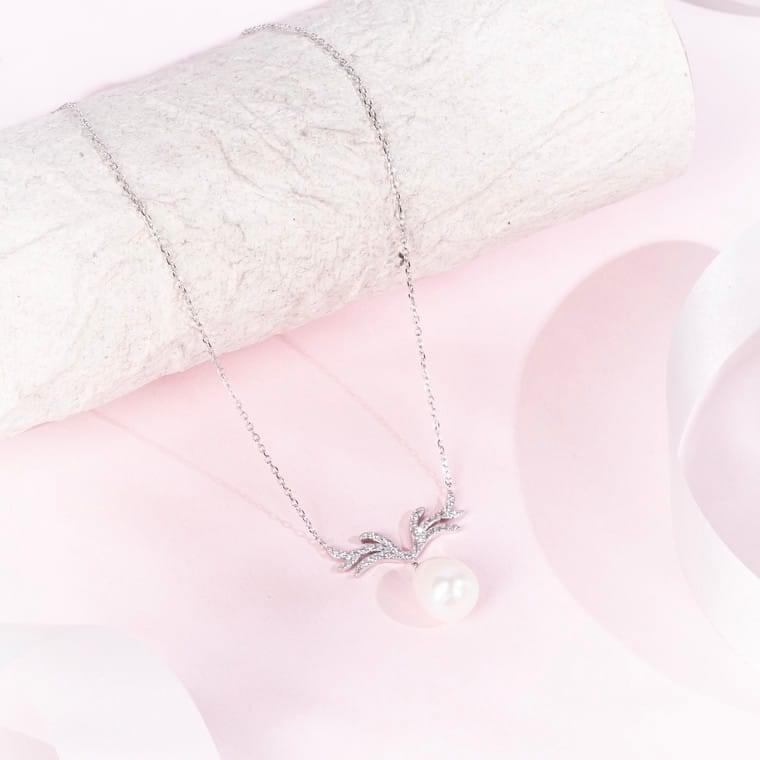 "Graceful antler-shaped pendant necklace accented with a single royal pearl"
